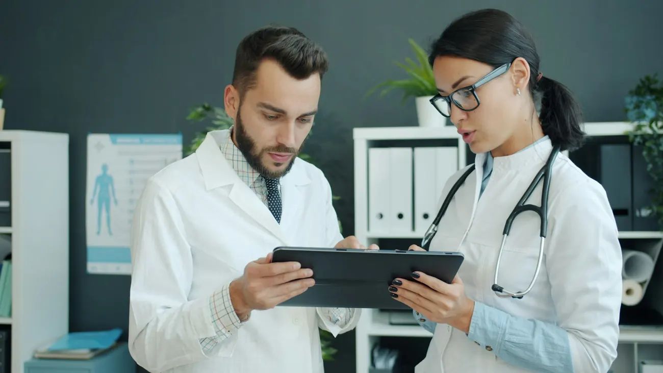 Dua dokter berdiskusi dengan tablet